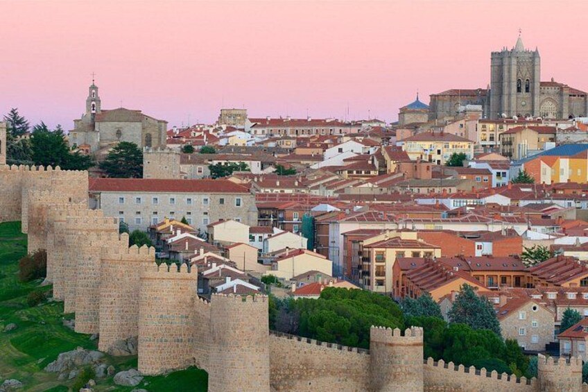A historic cityscape with a prominent castle, a cathedral, and a dense urban area with traditional architecture. 4