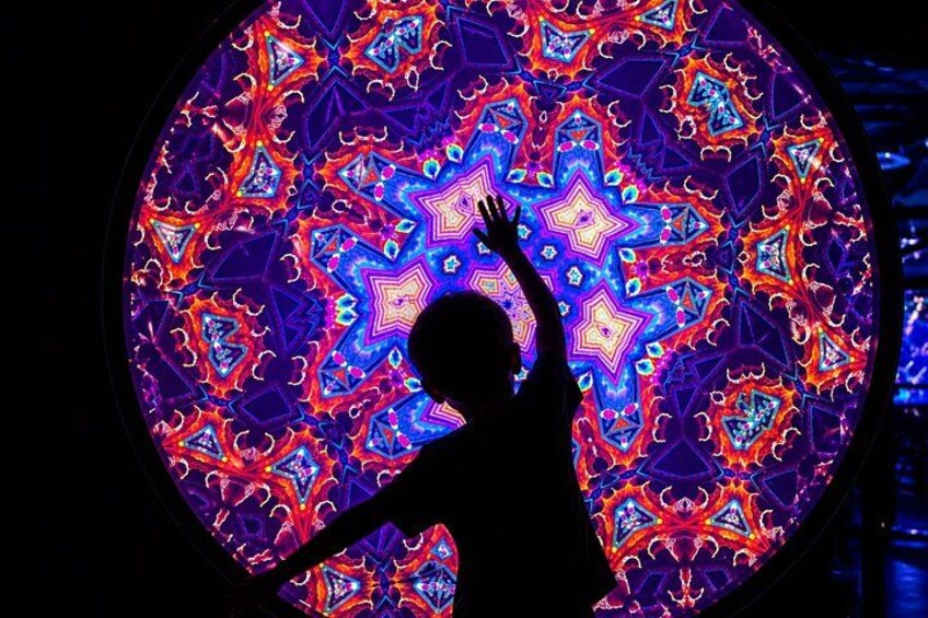 A person silhouetted against a vibrant, circular, kaleidoscopic pattern. 5