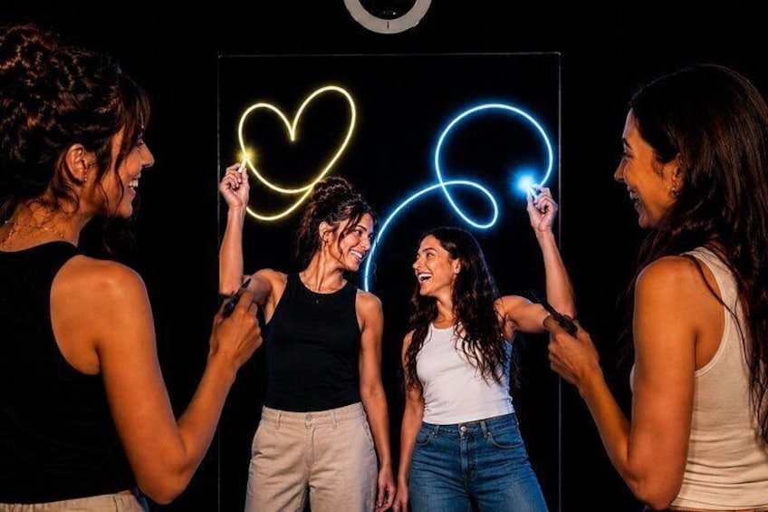 Cuatro personas sosteniendo luces de neón con forma de corazón. 2