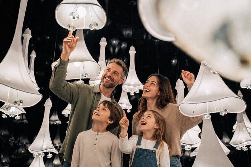 Una familia de cuatro personas en una tienda con lámparas colgantes blancas. 2