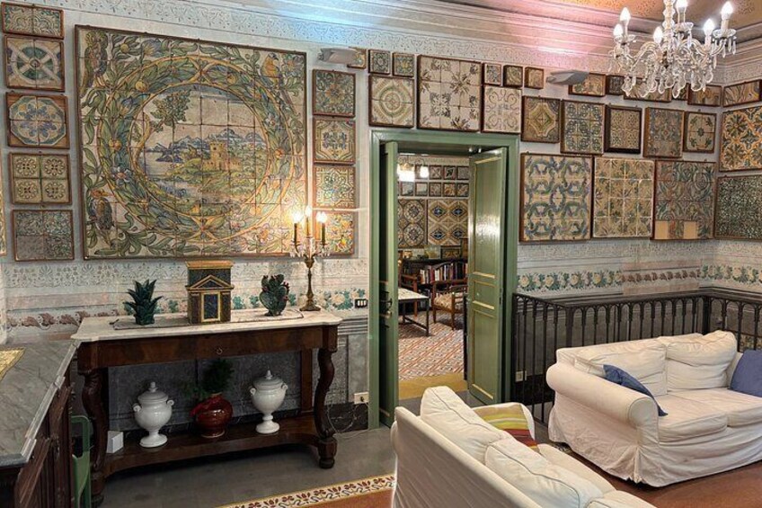 A room with a fireplace, a white sofa, a green door, and a tiled wall. 3