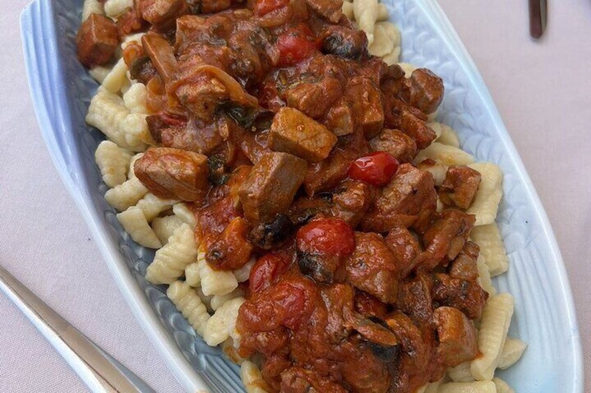 A plate of food with pasta and a meat-based dish. 1