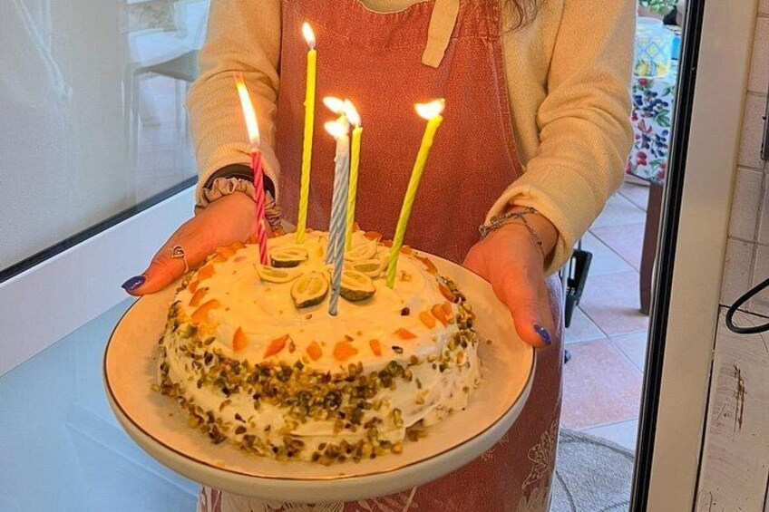 Una persona sosteniendo un pastel con velas encendidas. 5