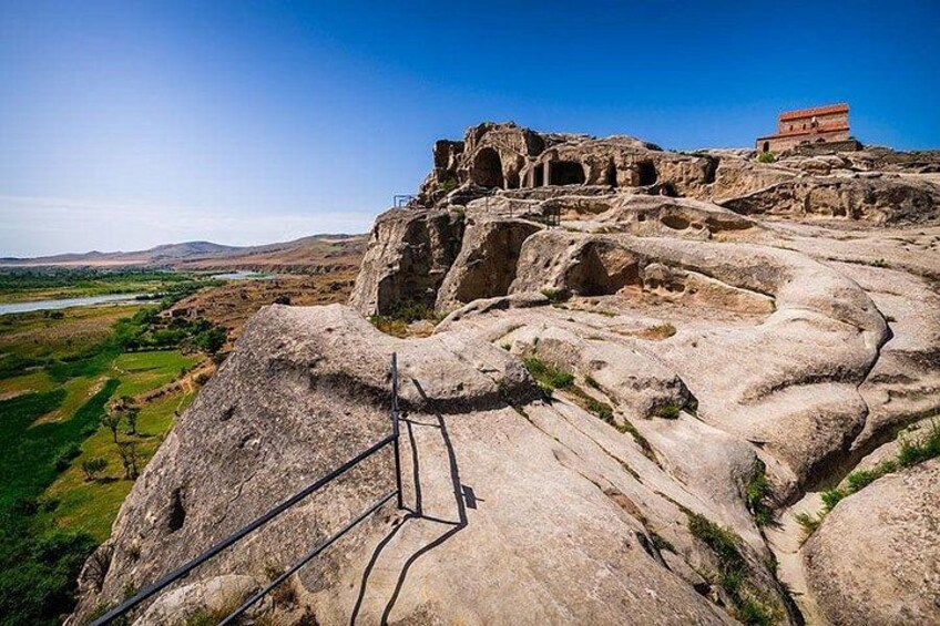 A rocky landscape with ancient ruins and a river in the background. 1