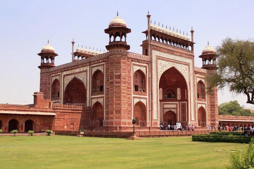 A large, historic building with multiple domes and arches, surrounded by a well-maintained lawn. 3