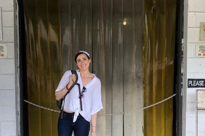 A person standing in front of a closed metal door with a chain across it. 3