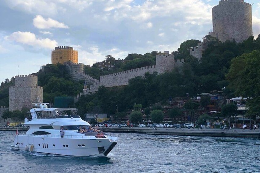 A white yacht on calm water, a historic castle on a hill, and a cityscape with buildings. 2