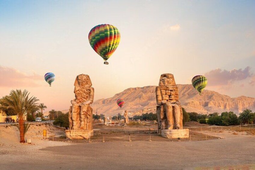 Paisaje desértico con estatuas de piedra antiguas y globos aerostáticos en el cielo. 4