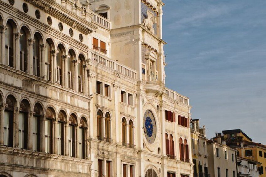 A historic building with arched windows and a clock tower. 2