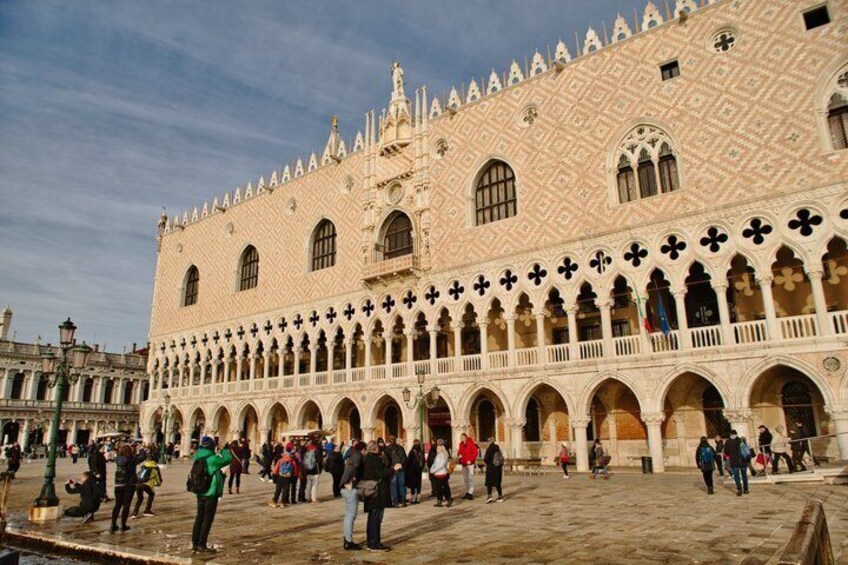 A historic building with a patterned facade and multiple arches. 1