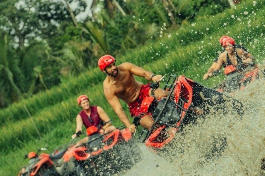 People riding off-road vehicles through a water splash. 4