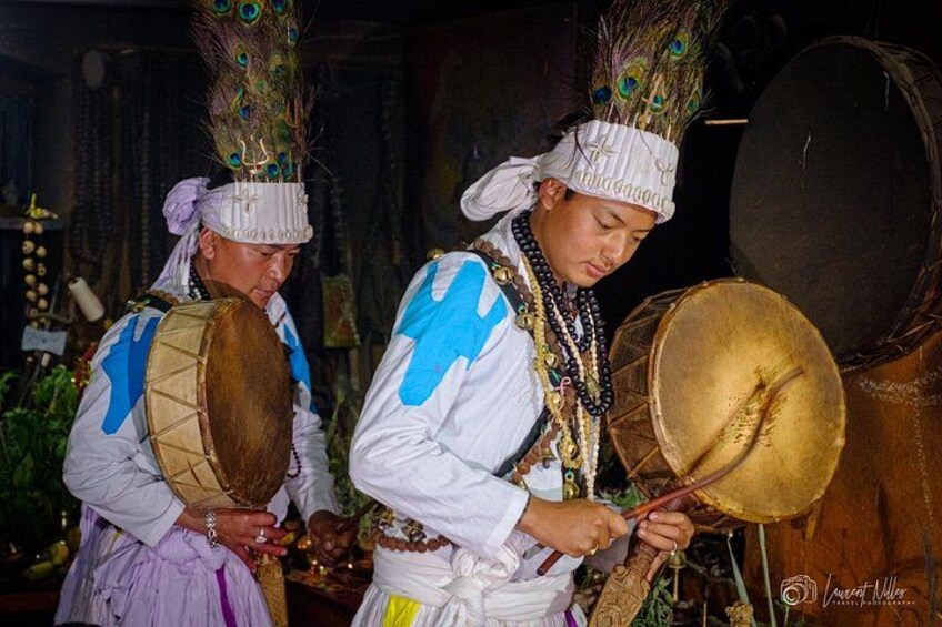 Två personer i traditionella dräkter som spelar trummor. 3
