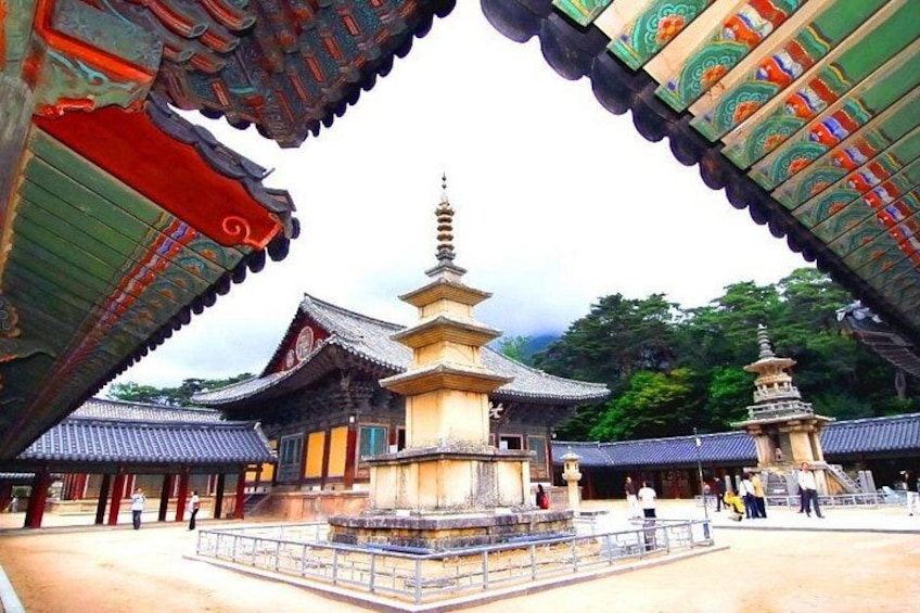 A traditional Japanese temple with a multi-tiered pagoda, a stone lantern, and a wooden gate. 5