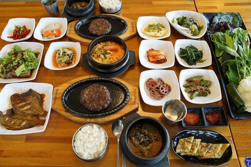 A variety of Korean dishes arranged on a wooden table. 2