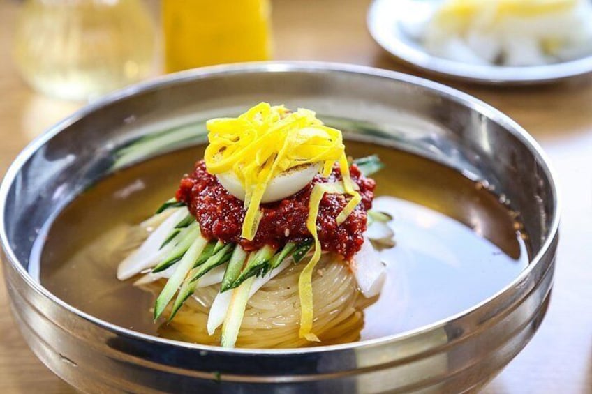 Eine Schüssel mit rohem Fisch, geriebenem Ingwer, roter Soße und einem gekochten Ei. 3