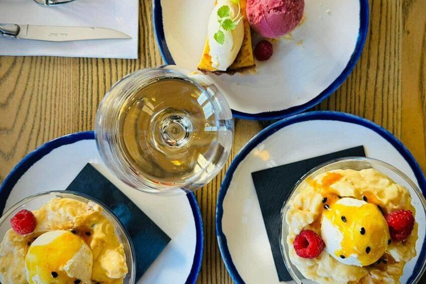 Trois assiettes de desserts aux fruits rouges et un verre de vin blanc sur une table en bois. 2