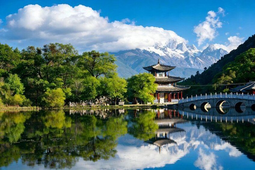 A traditional pagoda by a calm lake with mountains in the background. 4