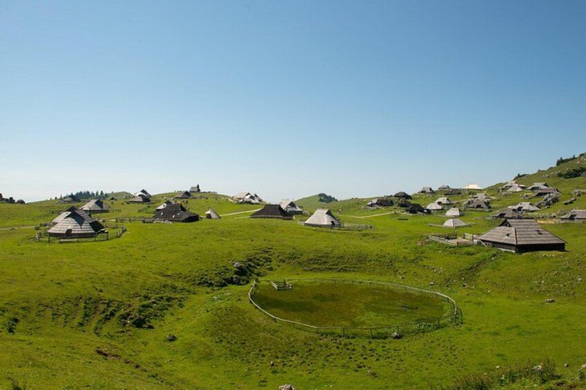 A rural landscape with multiple traditional houses on a hillside. 2