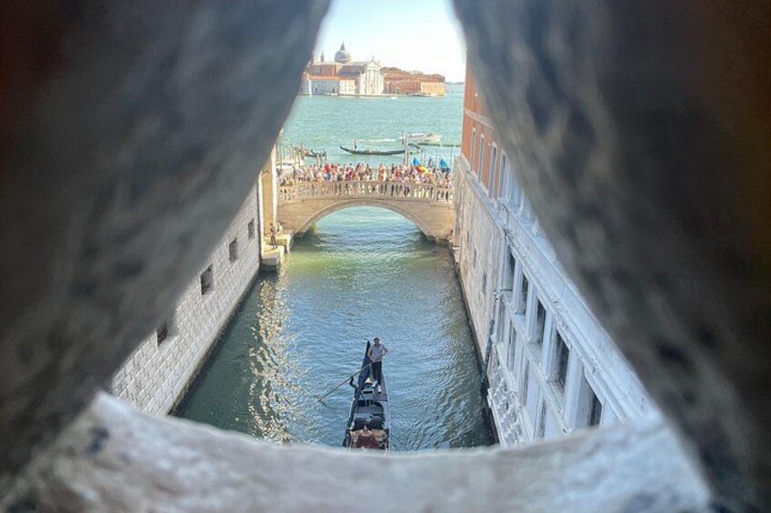 A canal with a bridge, gondolas, and a historic building in the background. 4