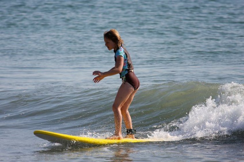 A person surfing on a yellow board in the ocean. 1