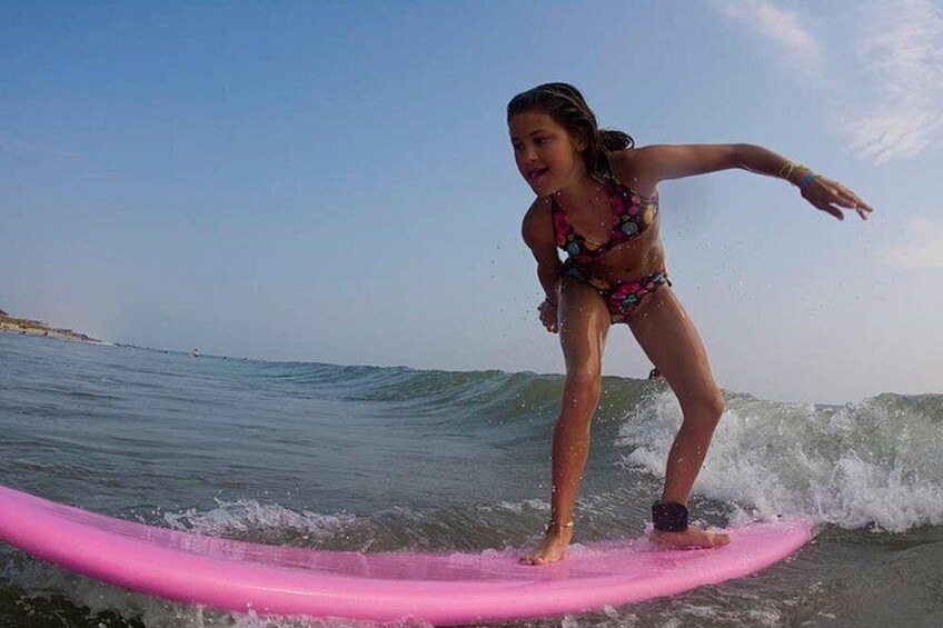Iemand surft op een roze surfboard in de oceaan. 3