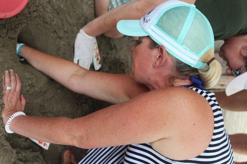 A person digging in the sand. 4