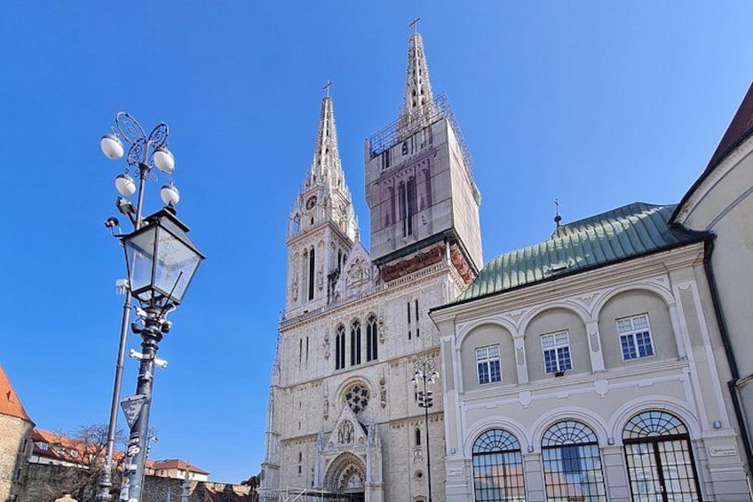 En historisk katedral med två likadana tornspiror, ett klocktorn och en gatlykta. 3