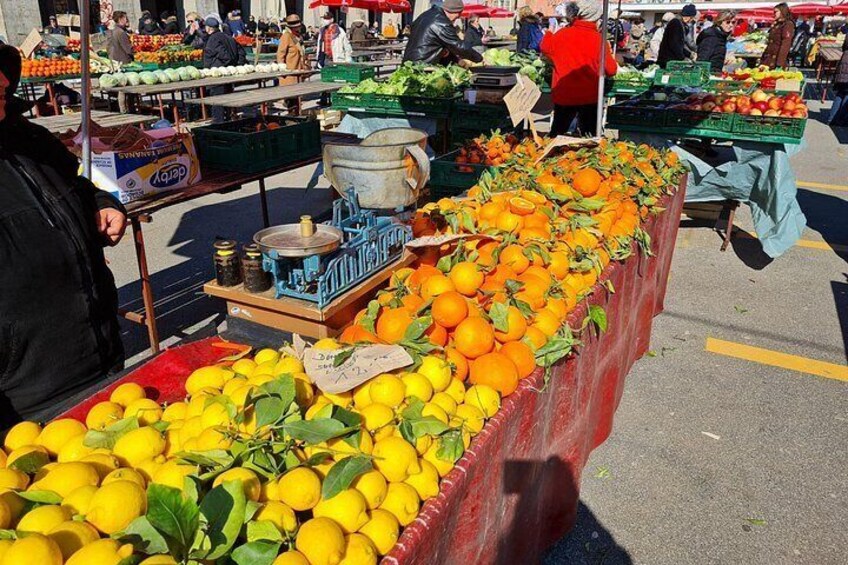 Un mercado de frutas con mesas de limones y naranjas. 2