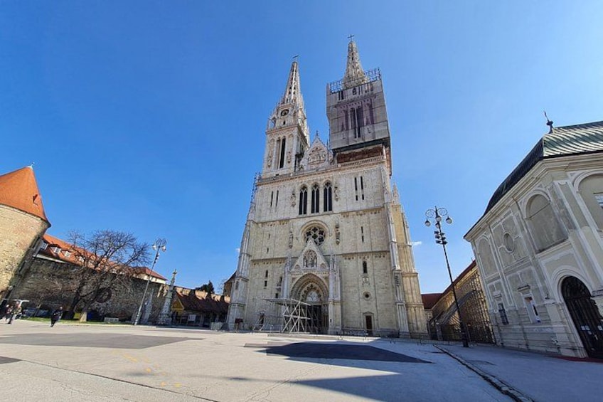 En katedral med två torn, ett stort, öppet torg och en byggnad med ett grönt tak. 2