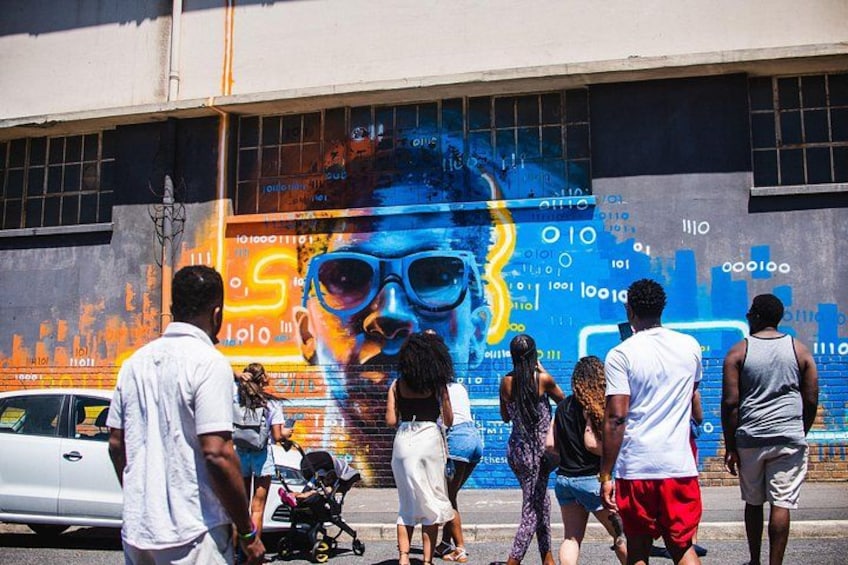 Un mural con una persona usando gafas de sol y un rayo amarillo. 1