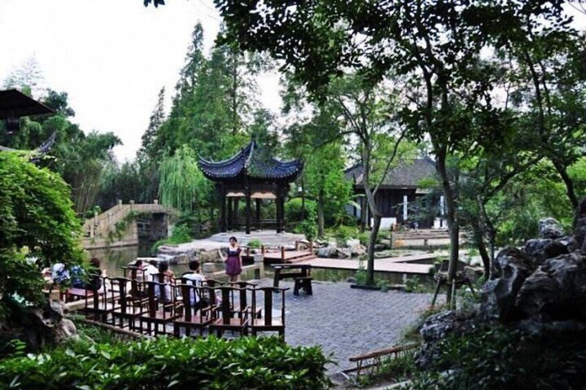 Ein traditioneller Pavillon, eine Steinbrücke und ein Teich in einem Park. 2