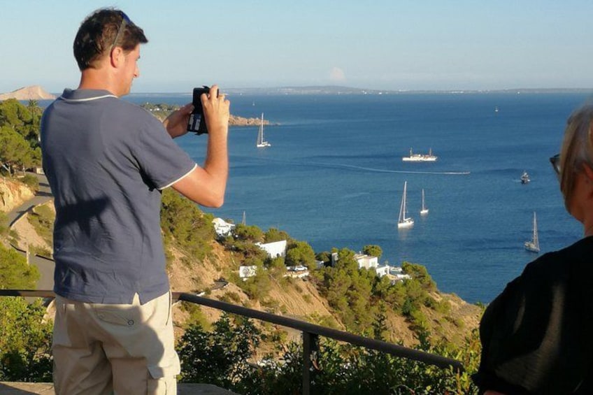 A person taking a photo of sailboats on the water. 2