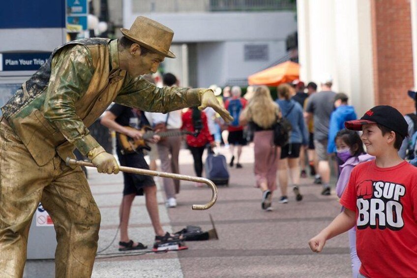 Un artista callejero disfrazado interactúa con un niño. 1