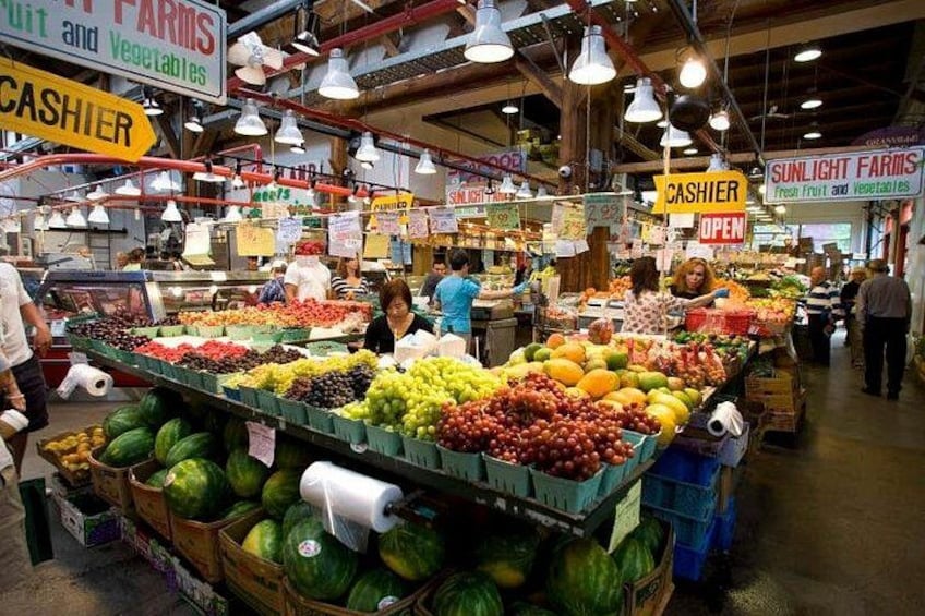 Un mercado cubierto con diversos puestos que ofrecen frutas y verduras. 3