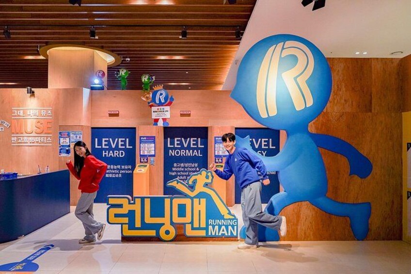 A running man sculpture, a large blue 'R' logo, and level signs. 1