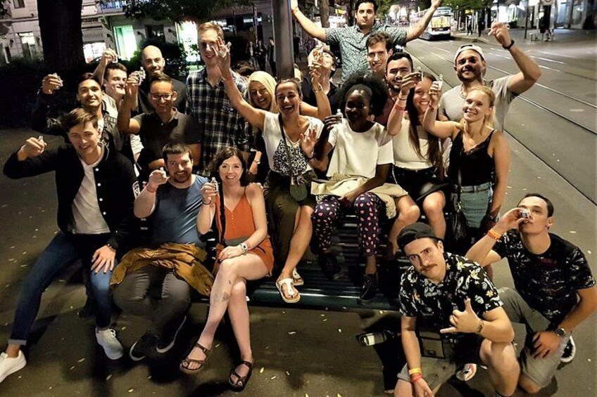 Un groupe de personnes posant pour une photo sur un banc, dans un environnement urbain. 4