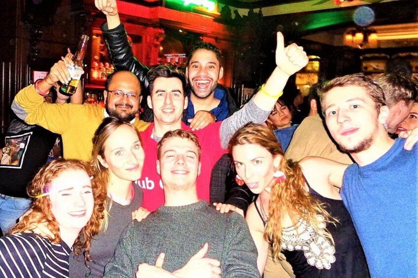 Un groupe de personnes réunies lors d’un événement social, dont certaines tiennent des boissons à la main. 5