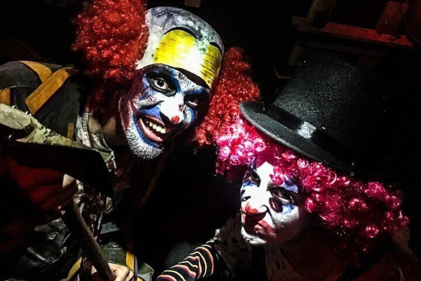 Två personer med clownsmink och röda peruker. 2