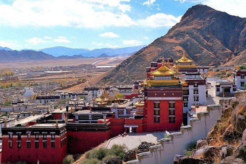 A mountainous landscape with a red-roofed building and a golden-domed structure. 5