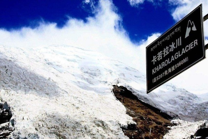 A snow-covered mountain with a sign indicating the location of Kharolag Glacier. 3