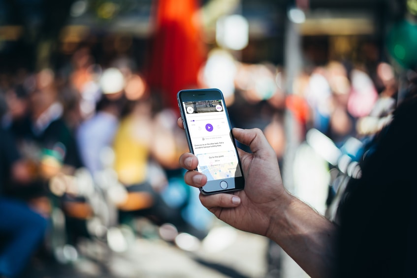 A person holding a smartphone displaying a map application. 2