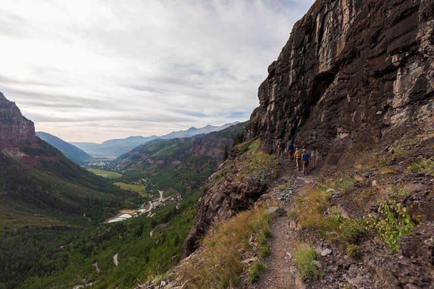 A hiking trail on a mountain ridge with a valley below. 2