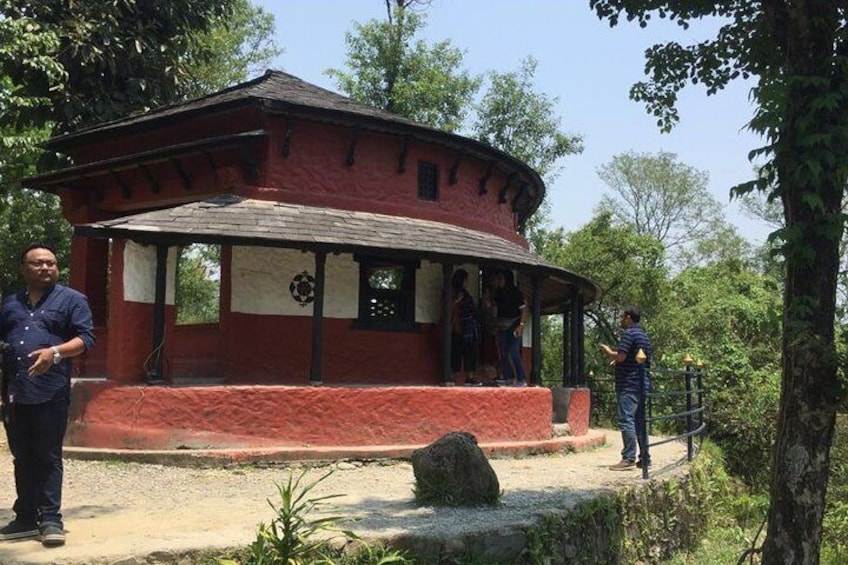 A red brick building with a covered porch, surrounded by trees and greenery. 4
