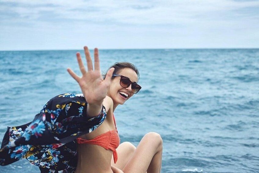 A person sitting on a boat with the ocean in the background. 3