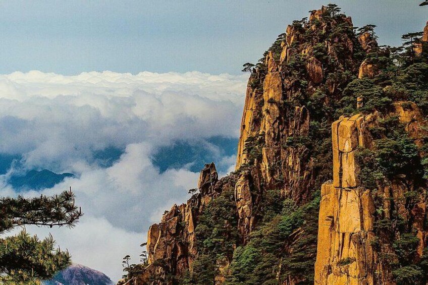 A mountainous landscape with rocky cliffs and a forested area. 1