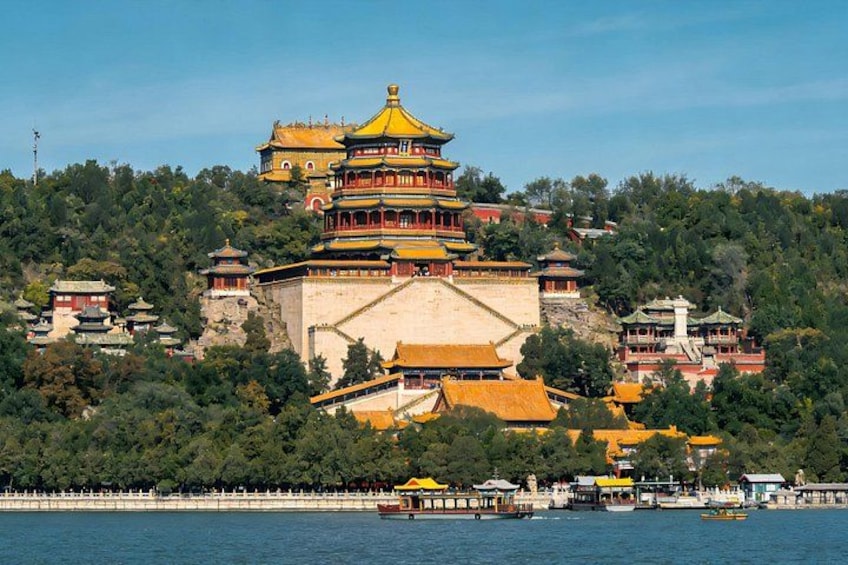 A traditional multi-tiered pagoda with a golden roof, surrounded by lush greenery and situated on a hillside overlooking a body of water with boats. 4