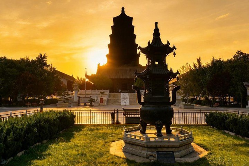 A pagoda, a traditional Chinese architectural structure, with a decorative fountain in the foreground. 3