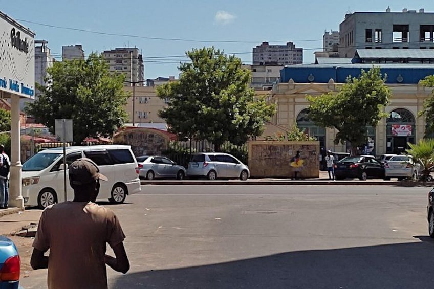 Una calle con coches aparcados, un hombre caminando y edificios al fondo. 4