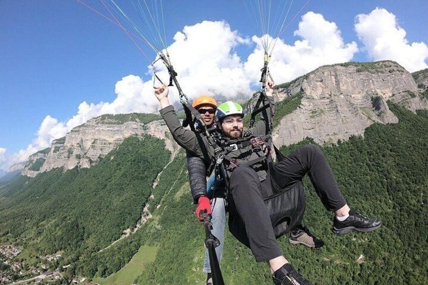 Deux personnes pratiquent le parapente avec un paysage montagneux en arrière-plan. 3