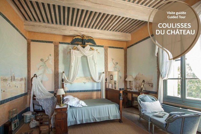 A bedroom with a bed, a chair, and a window. 2
